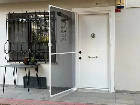 Giriş kapısına takılmış beyaz menteşeli sineklik