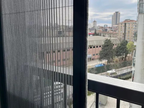 Yüksek katlı bir dairenin balkonuna takılmış dikey plise sineklik